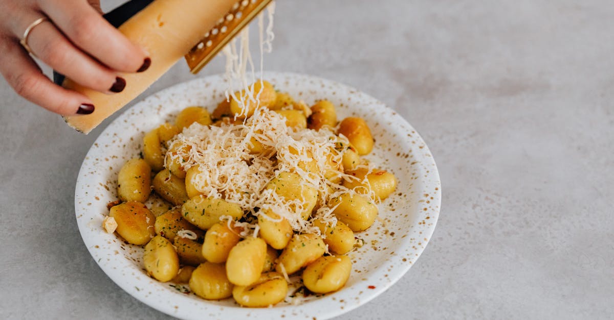 a ceramic plate of gnocchi with parmesan being grated by hand highlighting italian cuisine 1