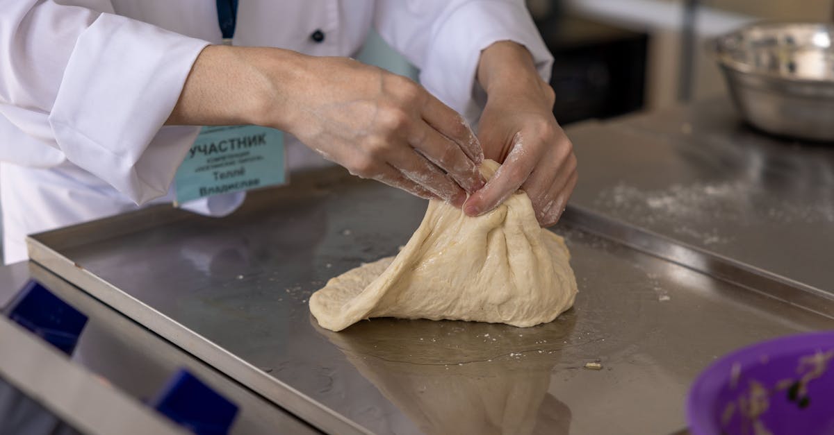 a chef skillfully kneads dough on a metal surface in a modern culinary setting