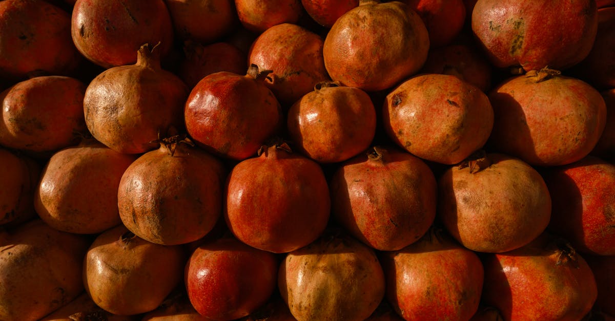 a close up view of a pile of fresh pomegranates stacked together highlighting their rich red hues