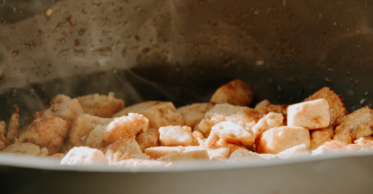 a close up view of tofu cubes being cooked in a frying pan 1