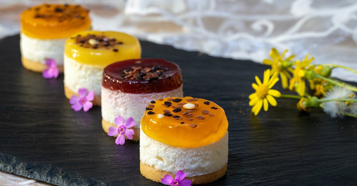 a collection of colorful mini fruit cakes with floral garnish on a slate platter perfect for summer