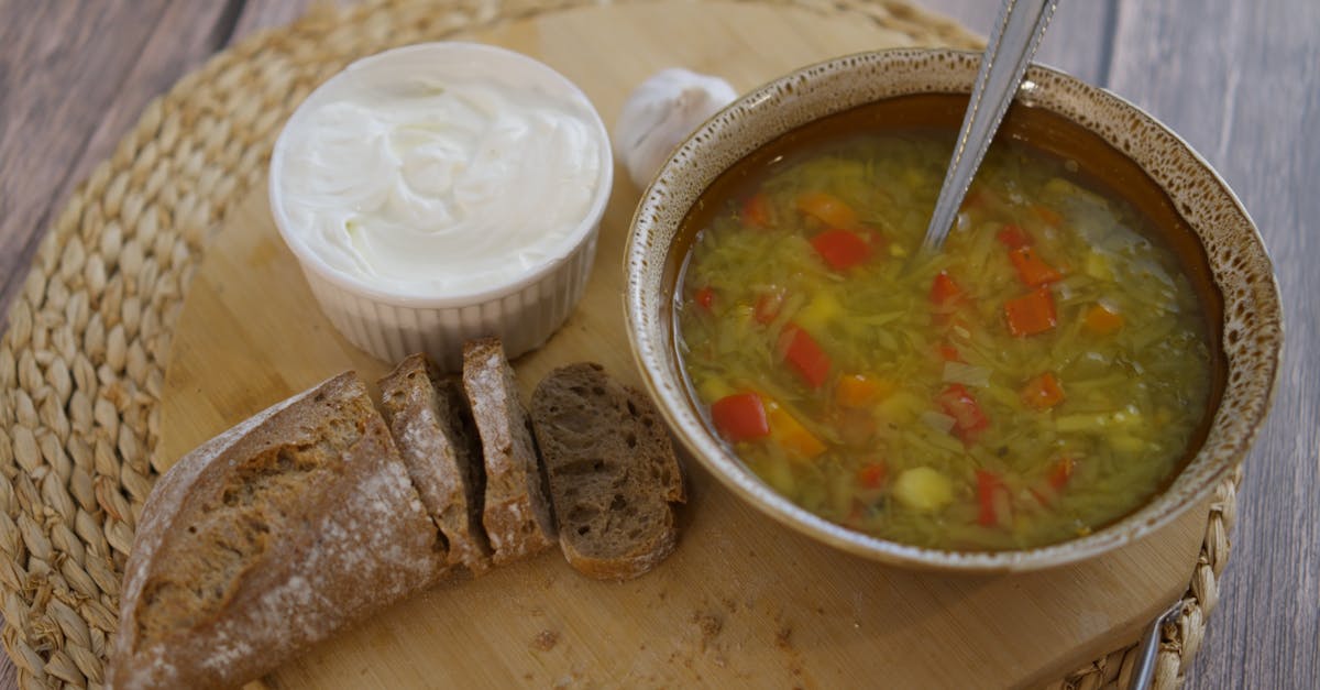 a cozy rustic lunch featuring vegetable soup with crusty bread and creamy spread