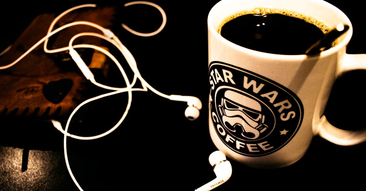 a dark themed setup featuring a star wars coffee mug and headphones on a table