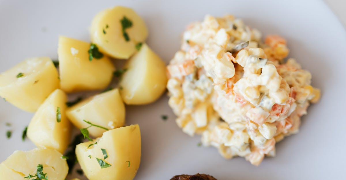 a delectable plate of potato salad with herbs served alongside boiled potatoes and a meatball perf 1