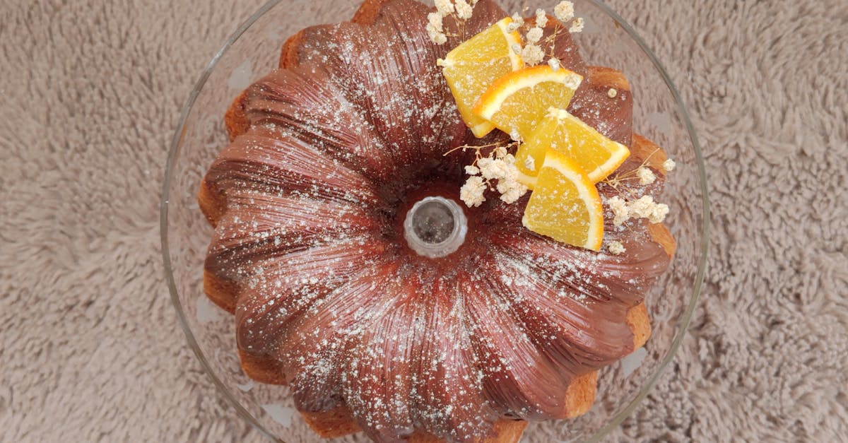 a delicious bundt cake topped with orange slices and powdered sugar on a textured surface