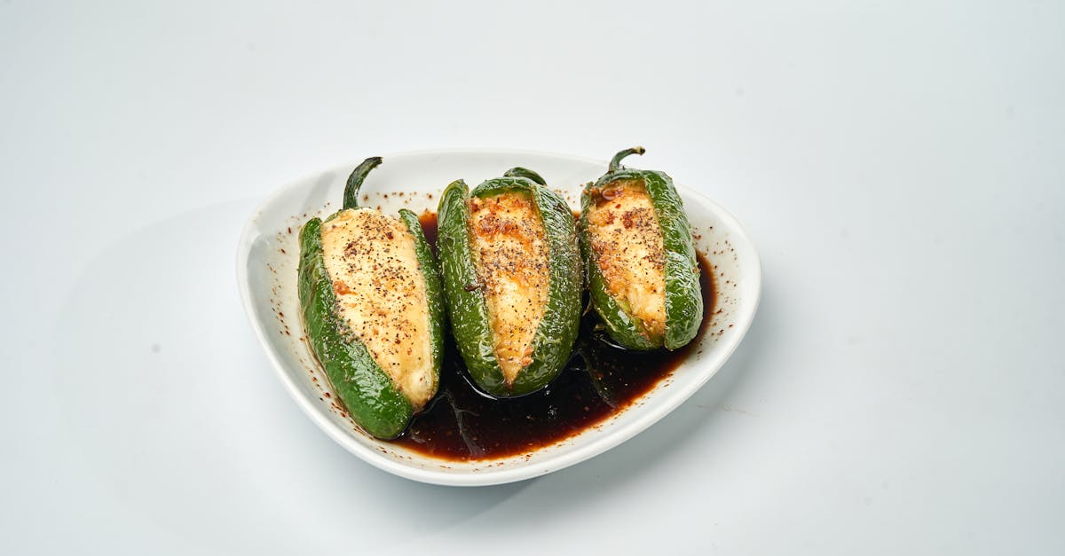 a delicious plate of baked jalapenos stuffed with cheese and drizzled with sauce