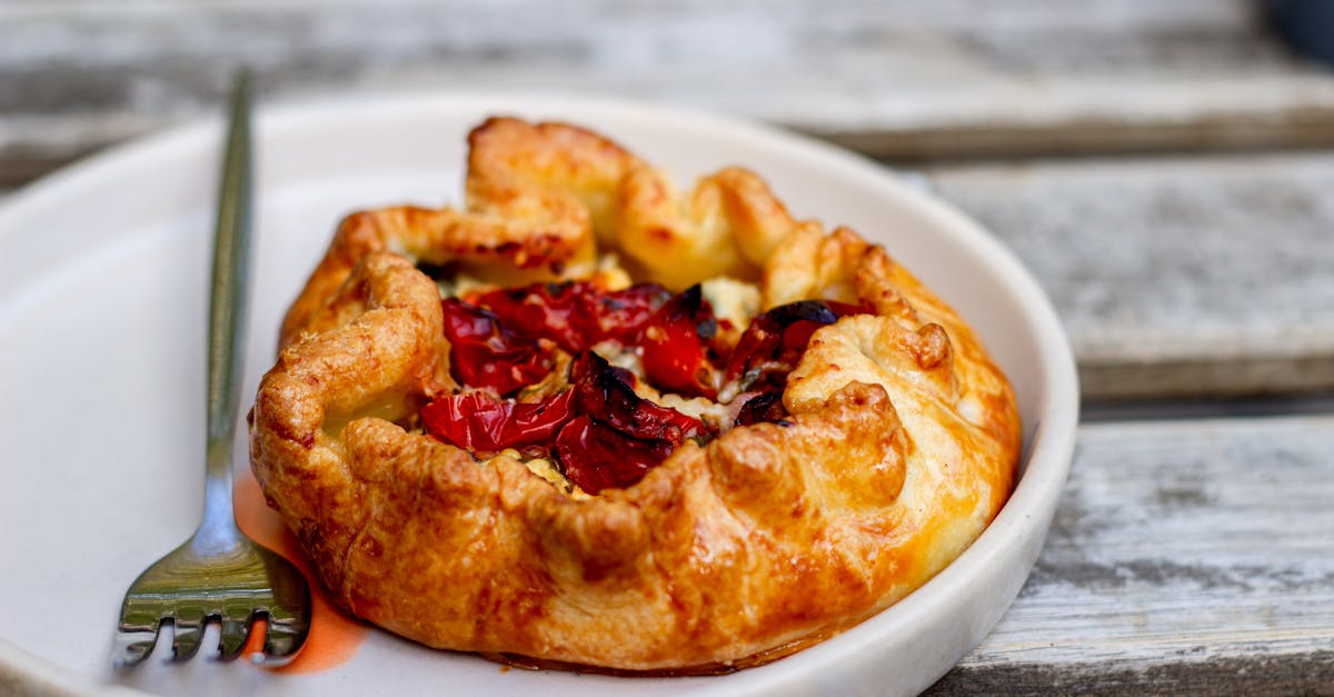 a delicious tomato galette on a plate with a fork perfect for a gourmet meal