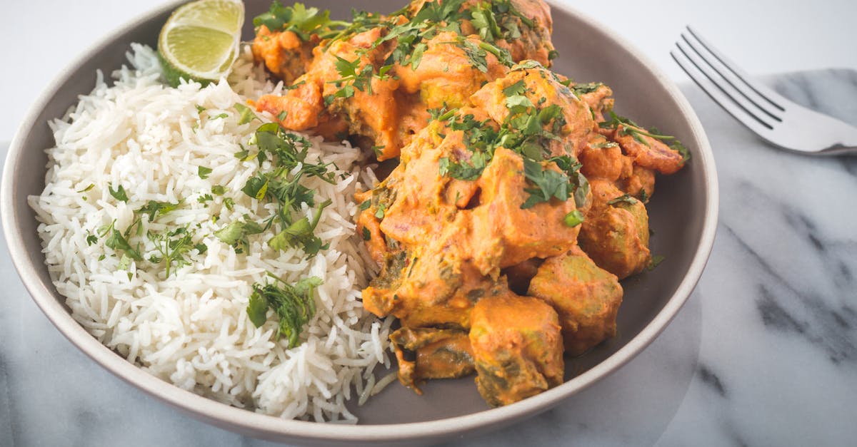 a flavorful indian curry served with jasmine rice and garnished with fresh herbs