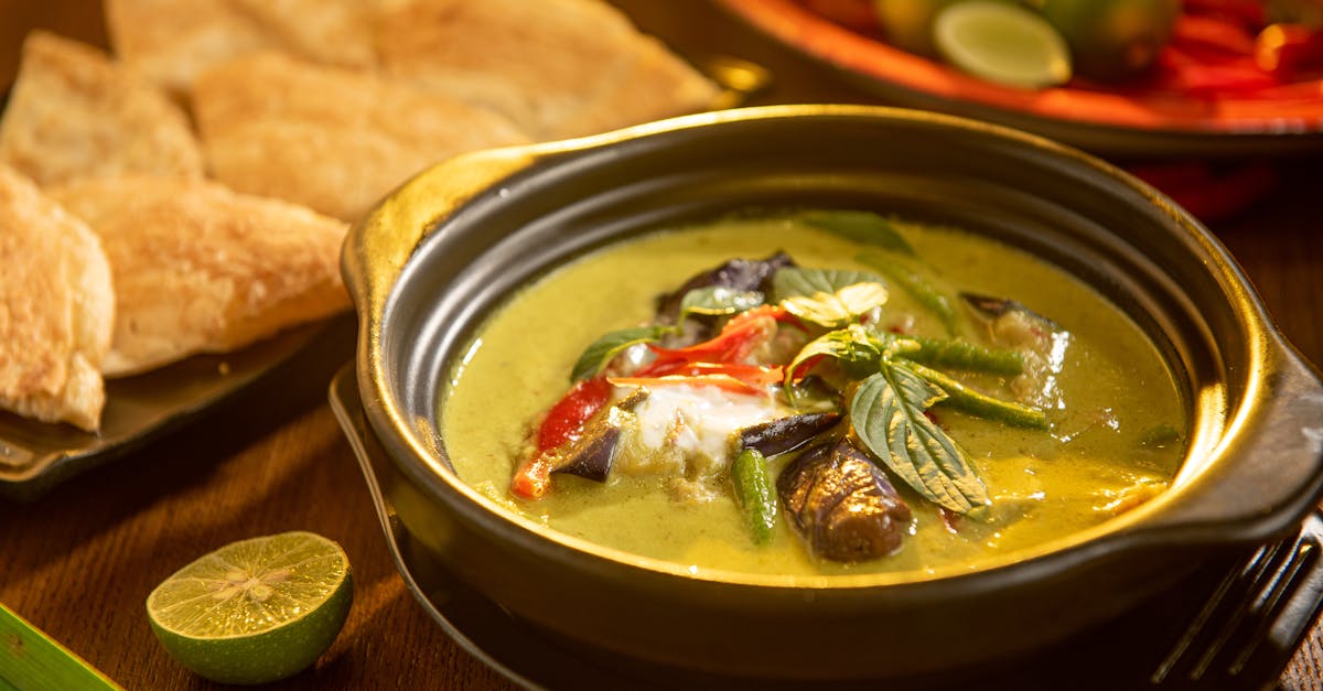 a flavorful thai green curry with vegetables and aromatic herbs in a stylish black bowl 3