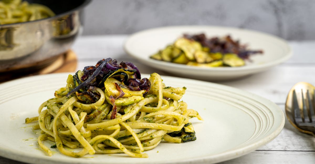 a flavorful zucchini pasta dish with pesto garnished with red onions perfect for a gourmet meal