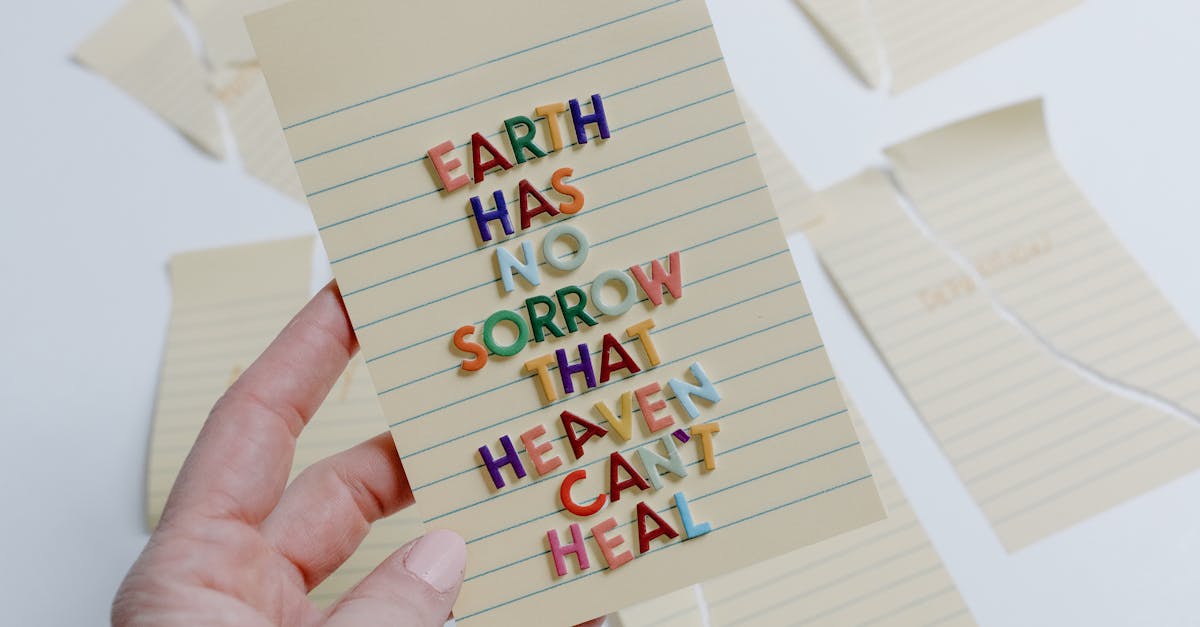 a hand holding a card with an inspirational quote using colorful letters