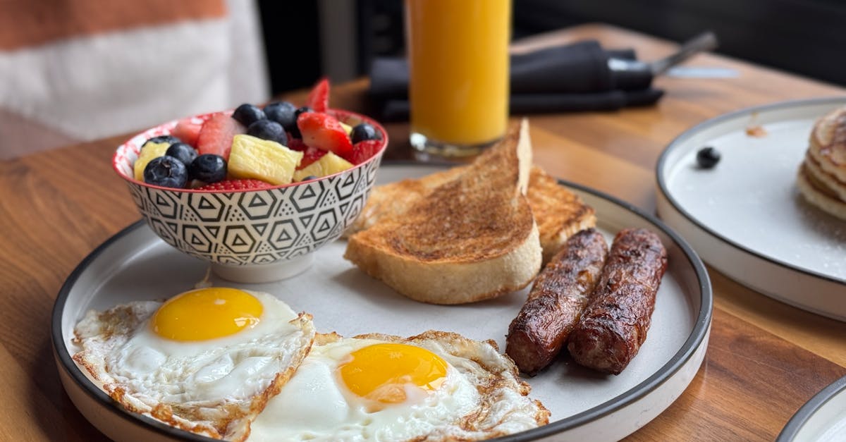 a hearty breakfast with sunny side eggs fruit bowl toast and orange juice 1