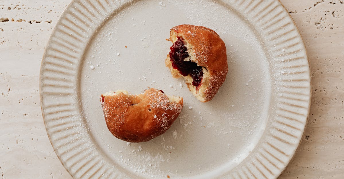 a mouth watering jelly donut halved on a ceramic plate perfect for food photography lovers