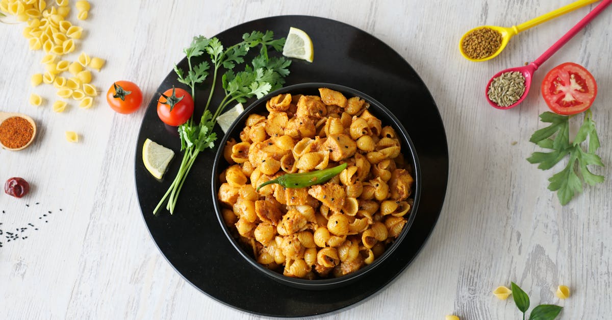 Home a mouthwatering shell pasta dish garnished with fresh herbs cherry tomatoes and spices