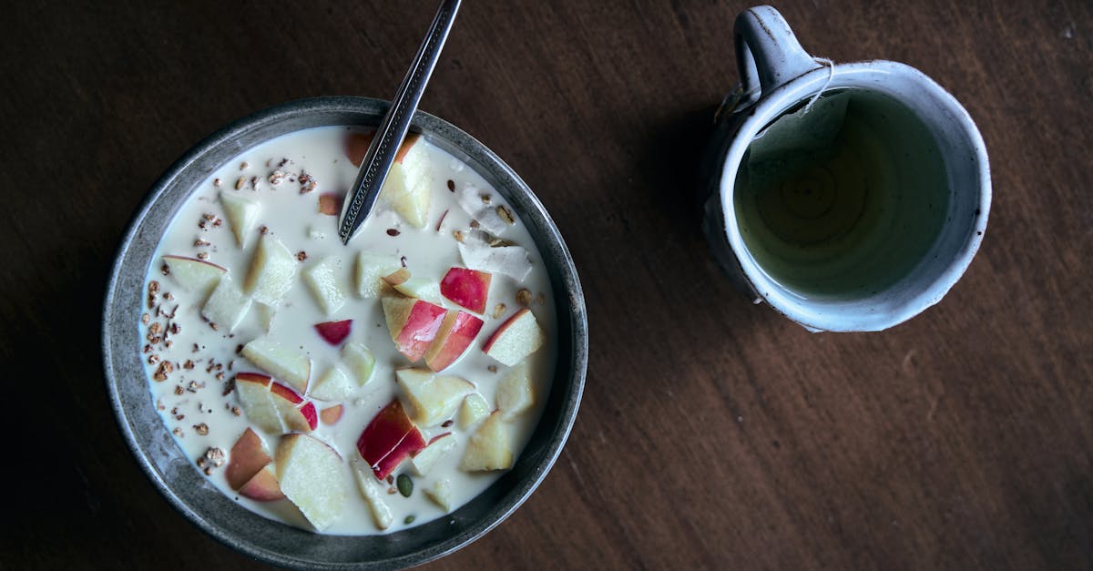 a nutritious breakfast bowl with sliced apples and cereal paired with a warm mug of tea
