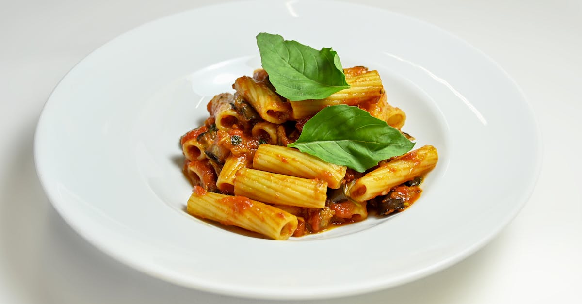 a plate of fresh rigatoni pasta in tomato sauce garnished with basil leaves perfect for italian cui 3
