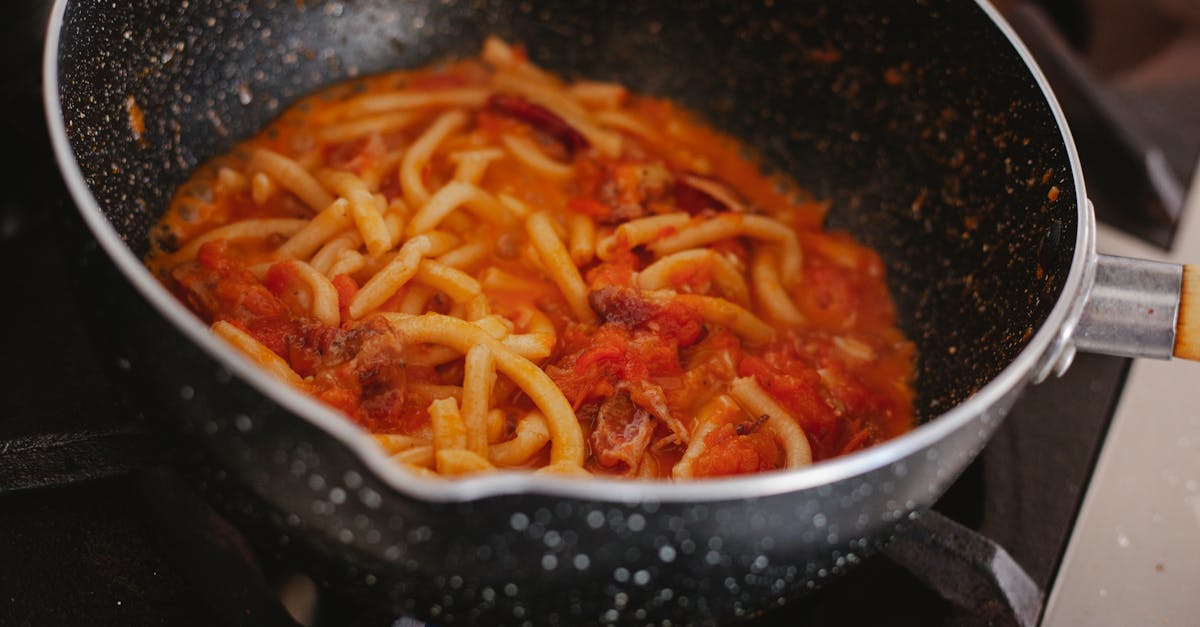 a savory pasta dish with rich tomato sauce cooked on a stove in a pot