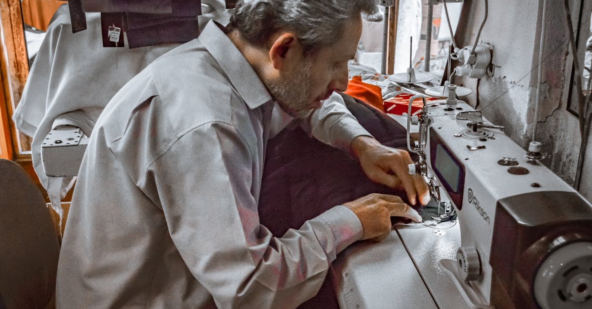 a skilled tailor focuses on sewing using an industrial sewing machine indoors