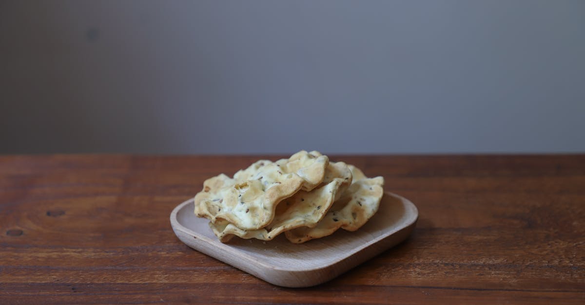 a stack of homemade crackers on a wooden plate perfect for a rustic snack or appetizer
