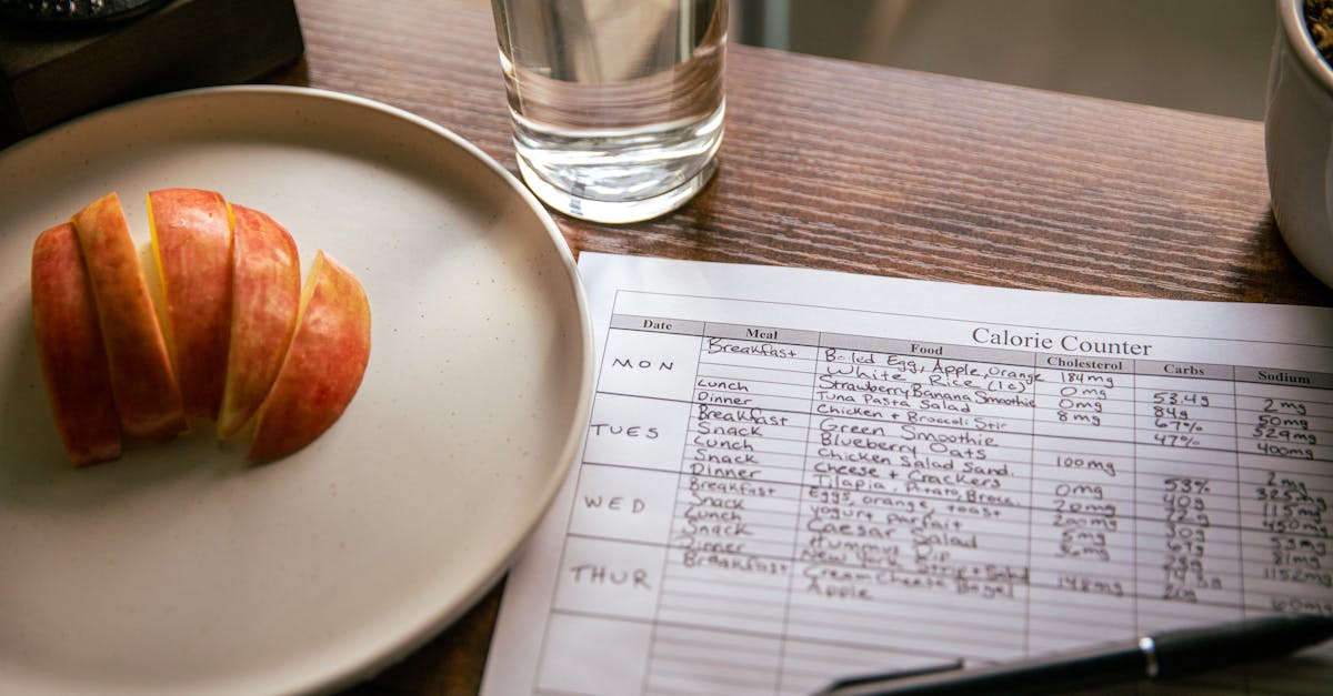 a table setup with apple slices a calorie counting sheet and a glass of water for a dieting scene