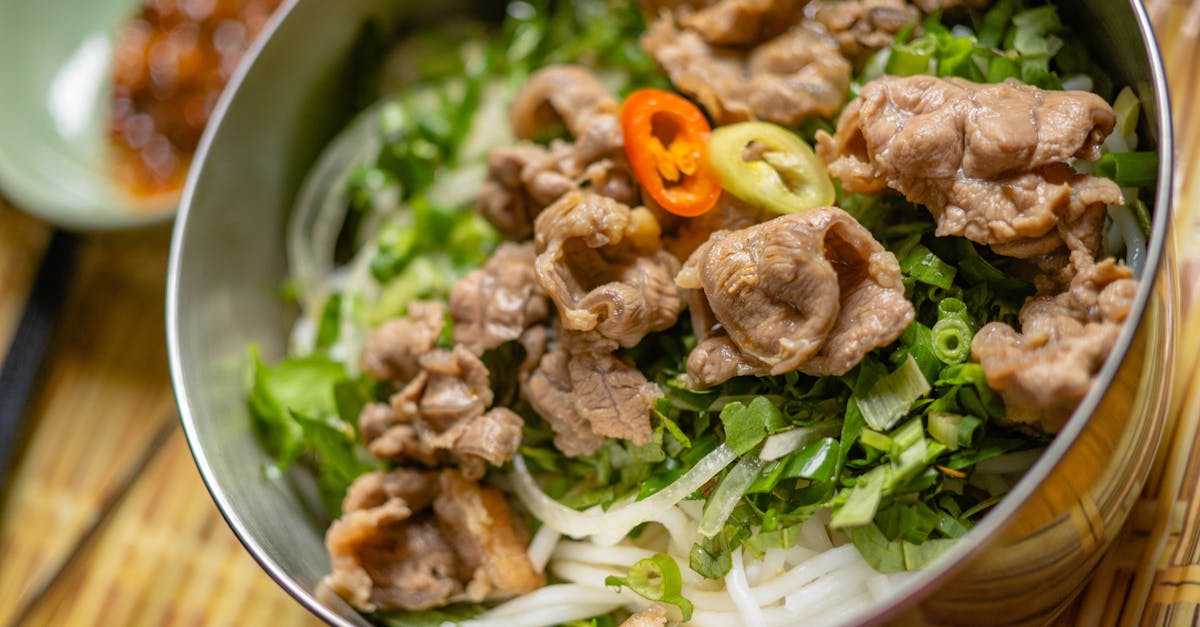 a tantalizing bowl of vietnamese beef noodles with fresh herbs and chili peppers