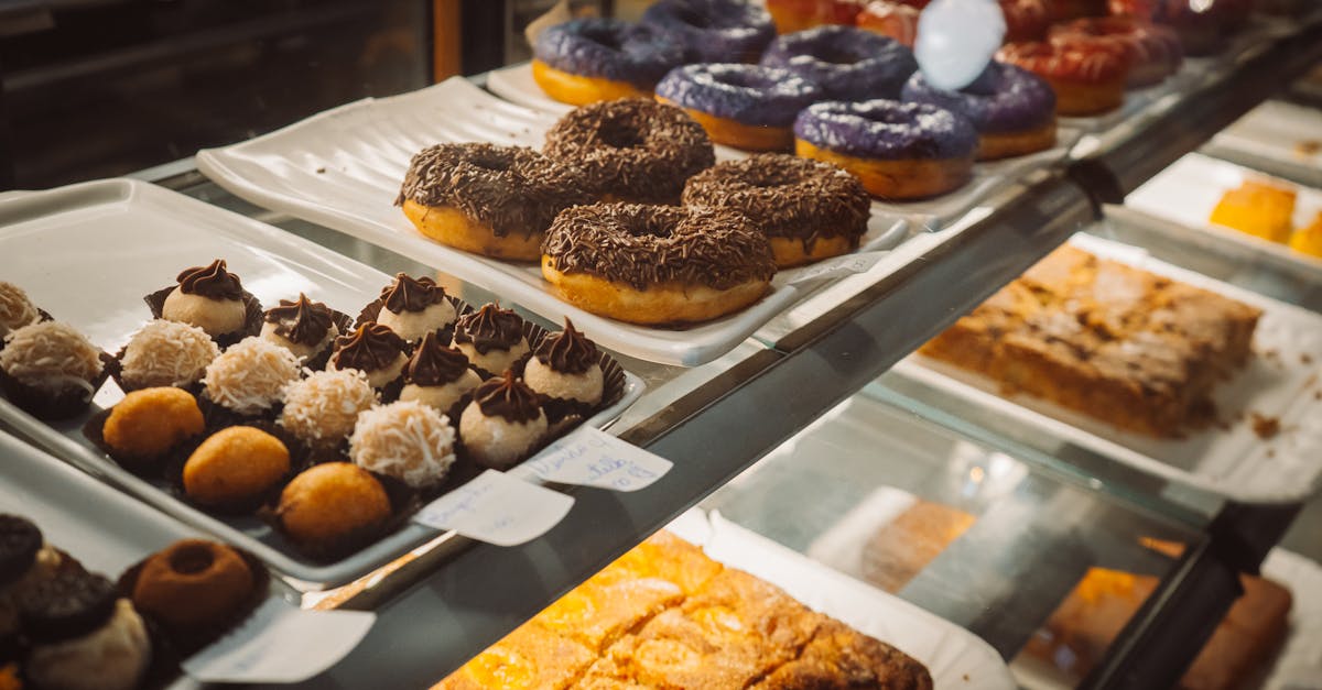 a variety of colorful donuts and pastries on display in a bakery case enticing and delicious