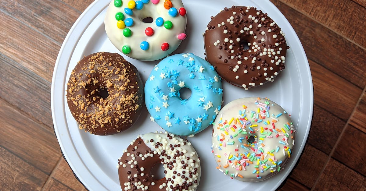 a vibrant assortment of decorated donuts placed on a white plate perfect for any dessert lover