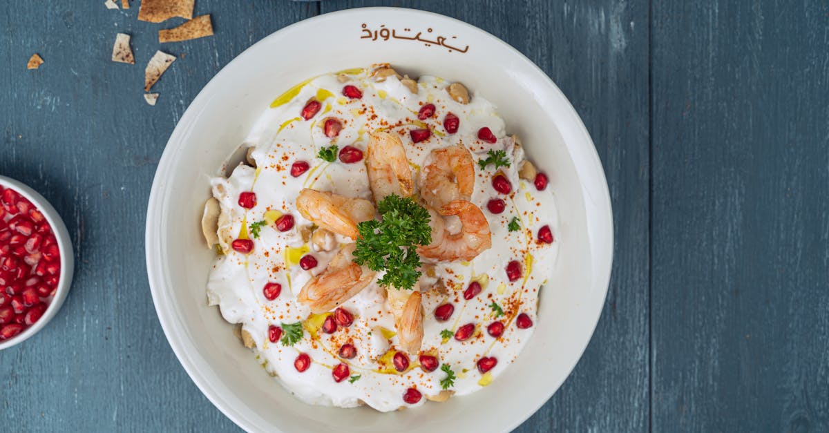 aerial view of a middle eastern shrimp dish with pomegranate on a wooden table