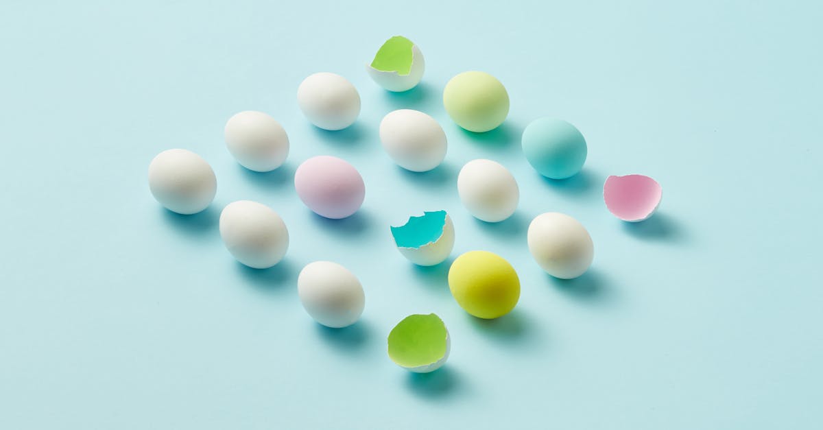 an artistic display of colorful eggs and cracked eggshells on a light blue background