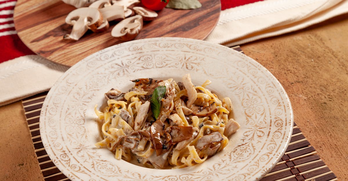 Home appetizing pasta in a creamy mushroom sauce garnished with herbs on a decorative plate