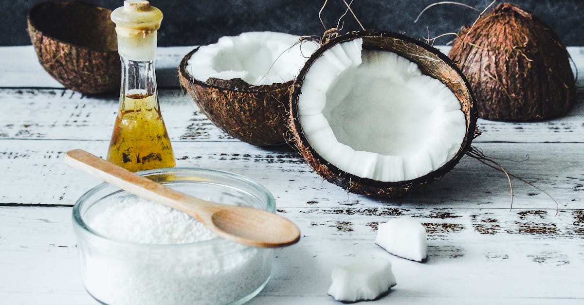 arrangement of coconut oil flakes and whole coconuts on a rustic wooden table