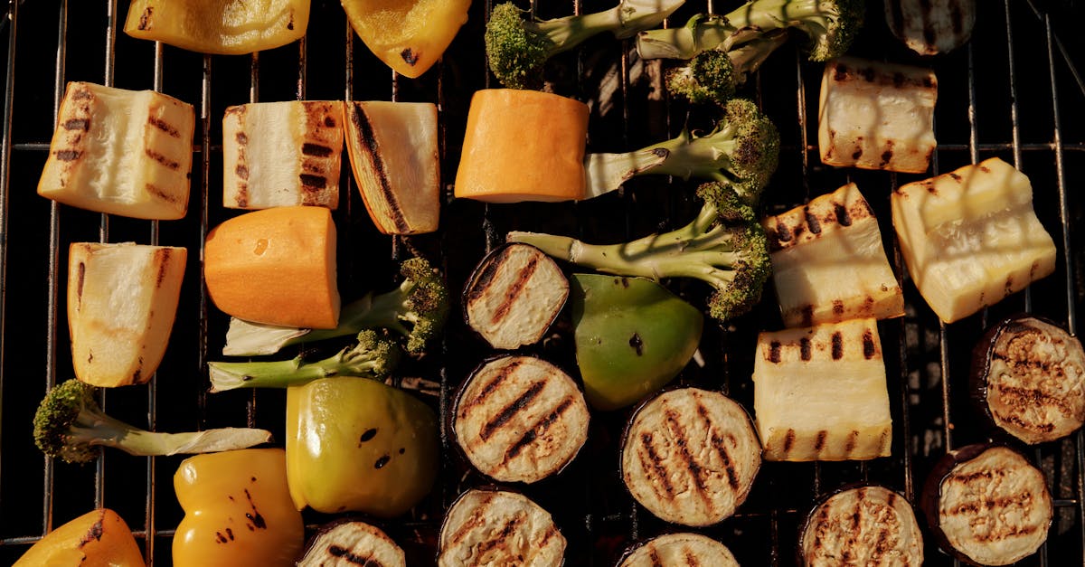 assorted grilled vegetables including peppers eggplant and broccoli on a barbecue grill