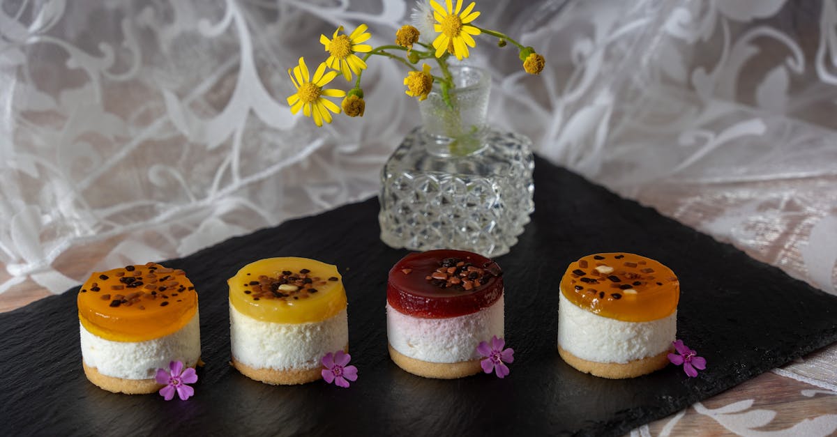 assorted mini fruit cheesecakes with vibrant toppings presented on a slate board with flowers
