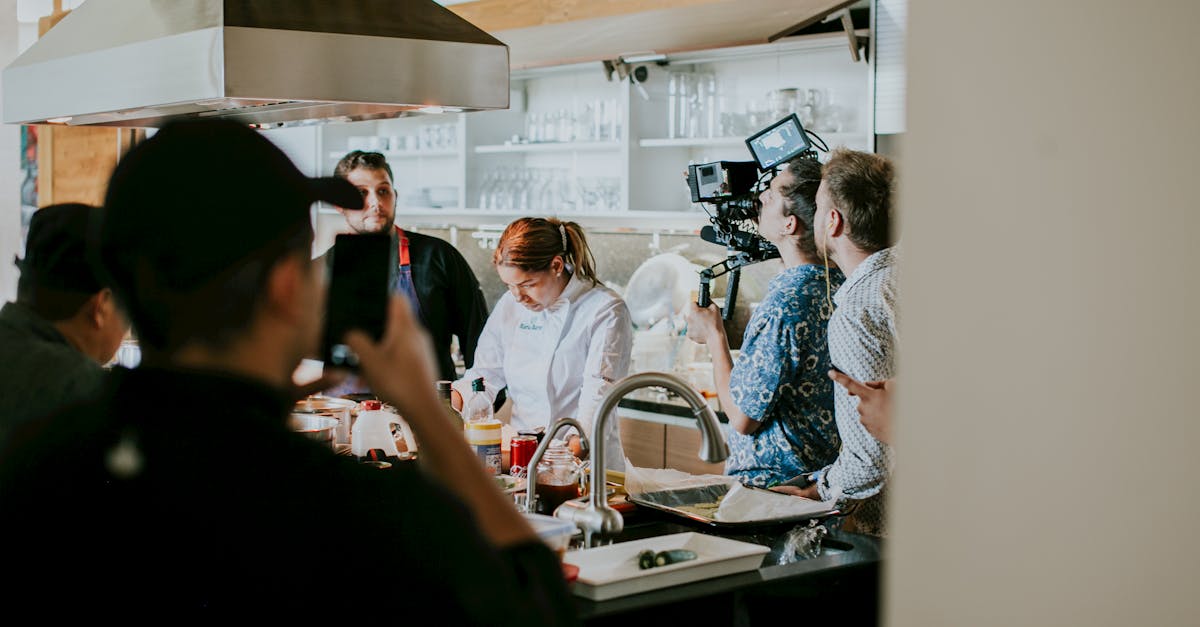 behind the scenes view of film crew capturing a cooking show in a professional kitchen setting