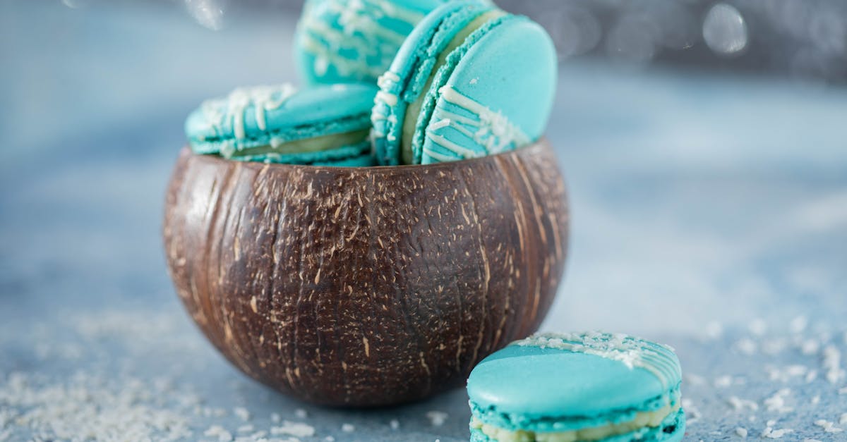 blue macarons in a coconut shell on a blue background delectable and colorful dessert presentation