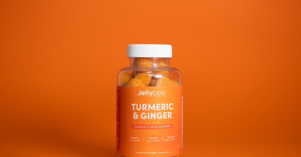 bright image of jellybee turmeric ginger gummies in a plastic bottle against an orange backdrop