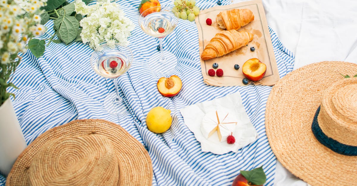 charming summer picnic featuring wine croissants and fresh fruits on a striped blanket