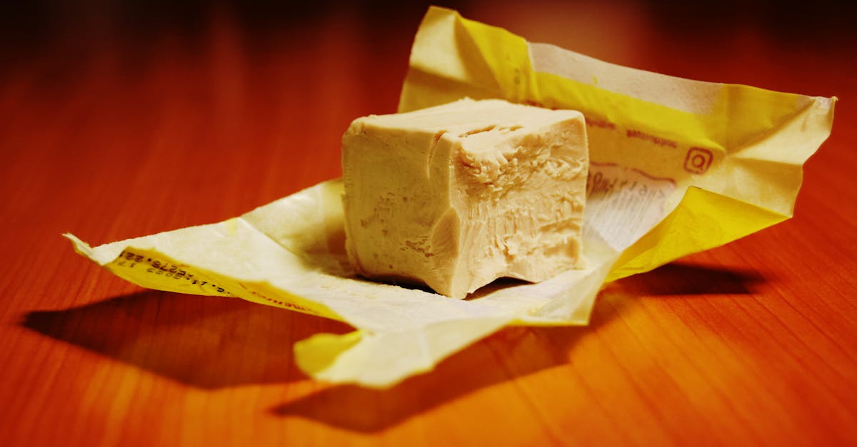close up of a block of yeast on a yellow paper wrapper ideal for baking scenes