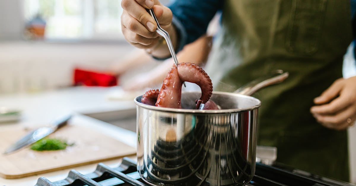 close up of a chef cooking octopus in a modern kitchen setting