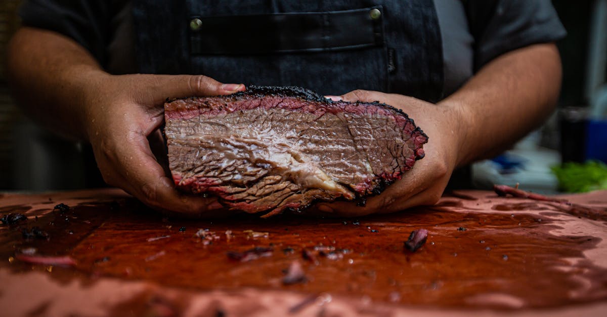 close up of a chef s hands holding a tender and juicy smoked brisket on a wooden board 2