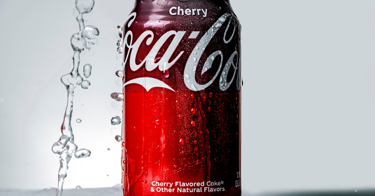 close up of a cherry flavored cola can with water droplets and splash effect