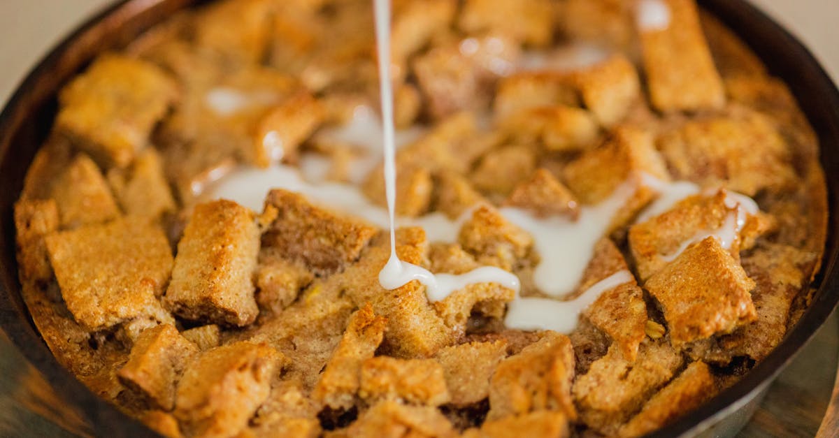 close up of a delicious bread pudding dessert with cream being drizzled on top 3