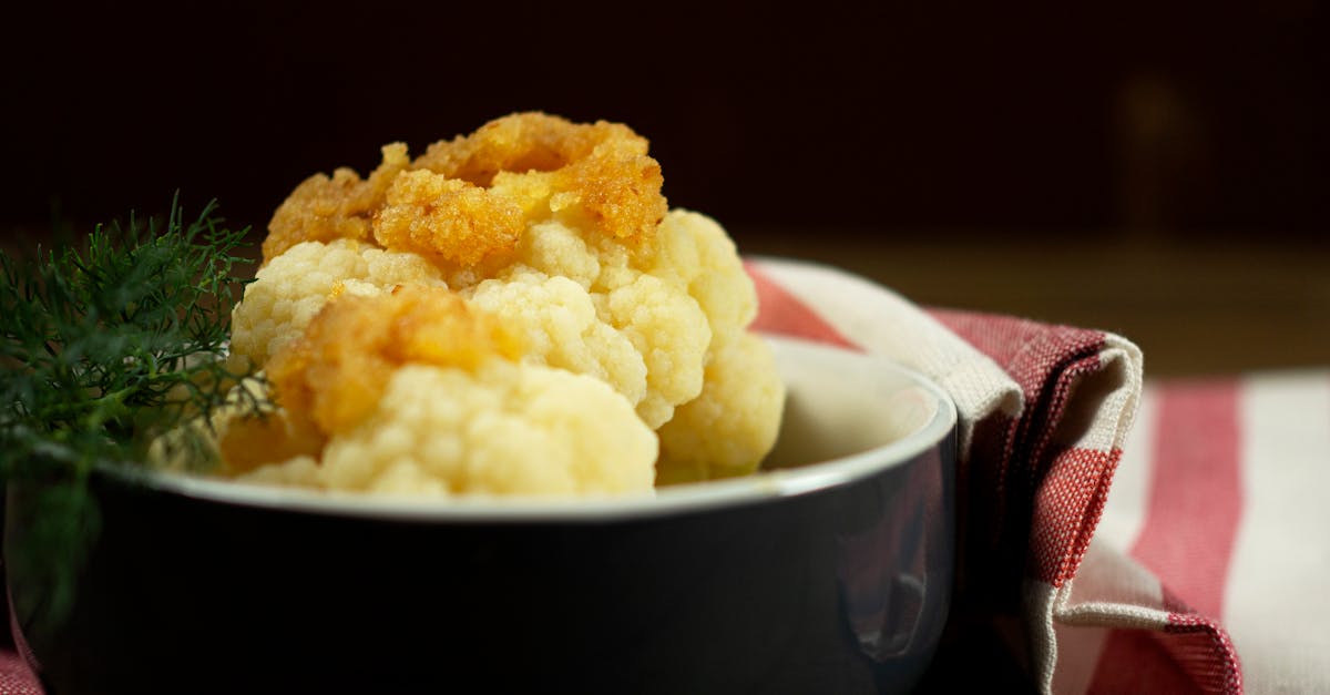 close up of a delicious fried cauliflower dish with herbs elegantly presented in a black bowl on st 1