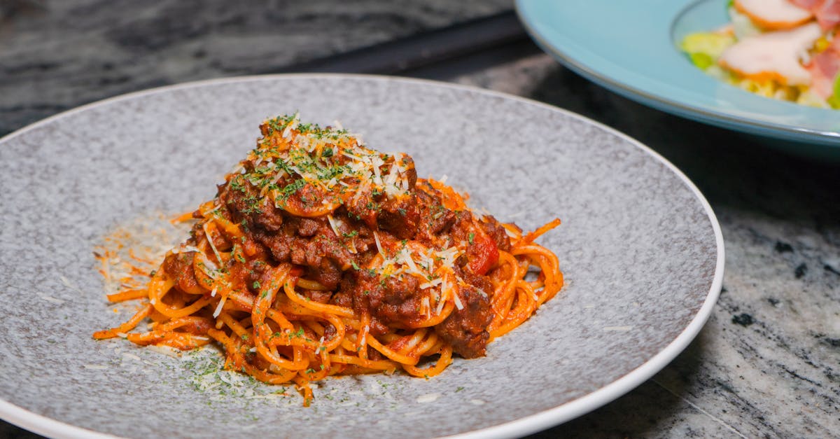 close up of a flavorful spaghetti bolognese topped with herbs and cheese 2