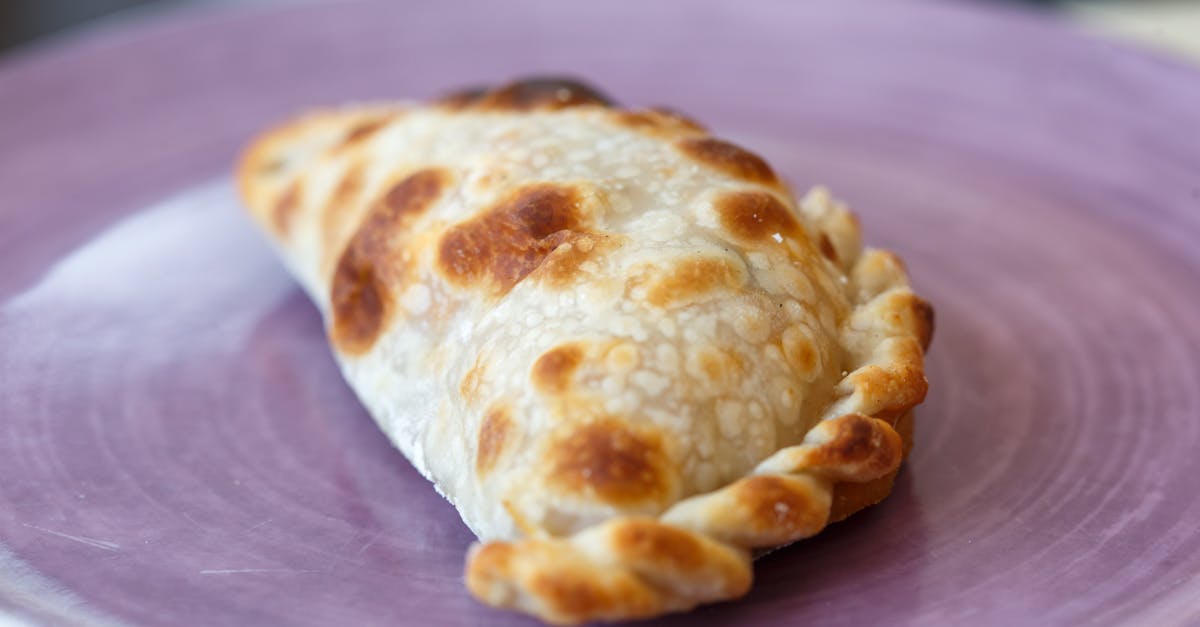 close up of a freshly baked argentine empanada on a purple plate showcasing authentic texture 3