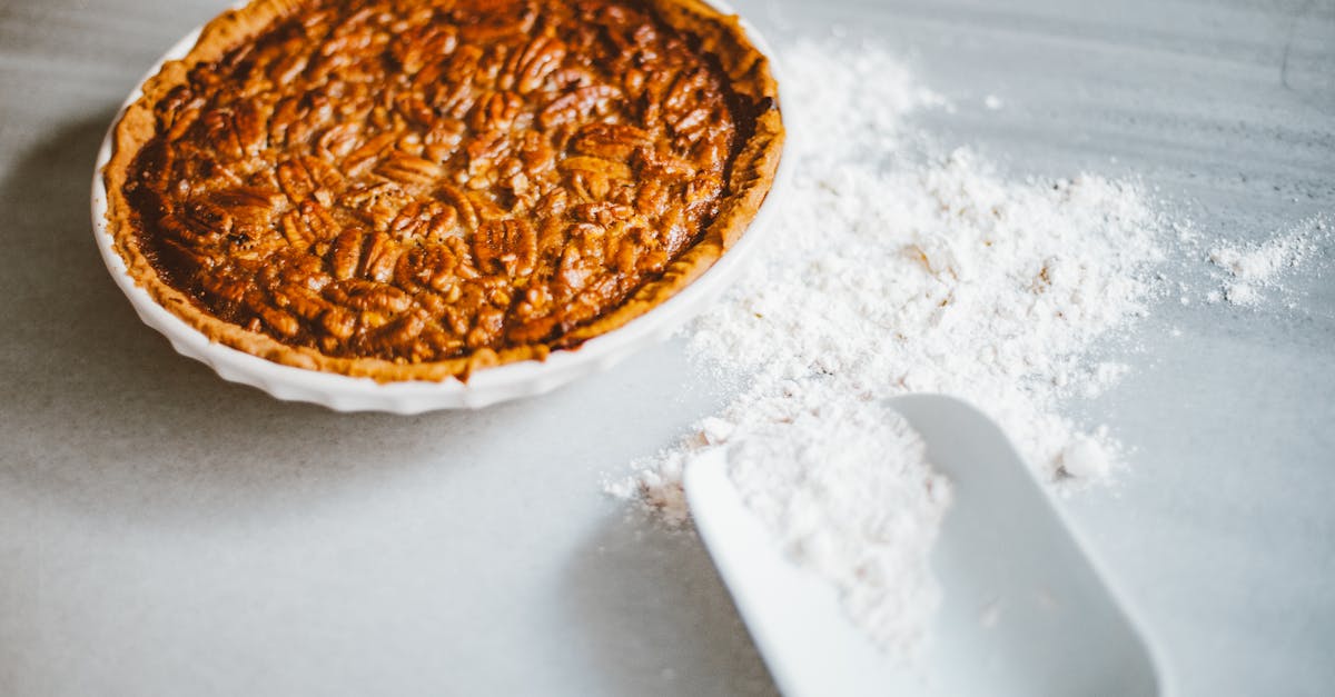 Home close up of a freshly baked pecan pie with scattered flour on a marble surface inviting dessert lov 6
