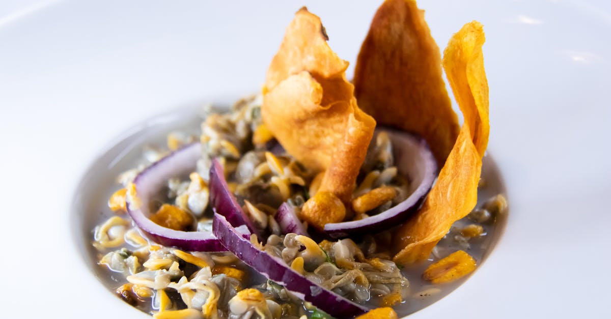 close up of a gourmet clam dish with crispy garnish and fresh onion slivers elegantly plated 1