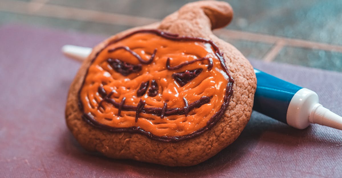 close up of a halloween pumpkin cookie decorated with orange icing perfect for the spooky season 6