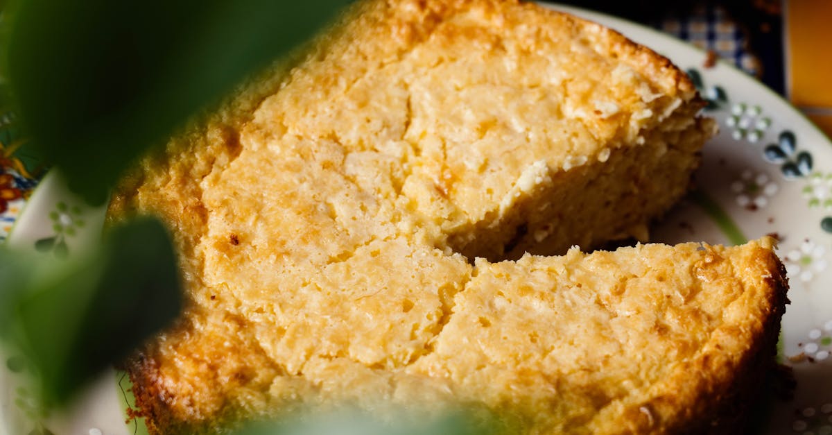 close up of a homemade elote cake with a missing slice on a decorative plate