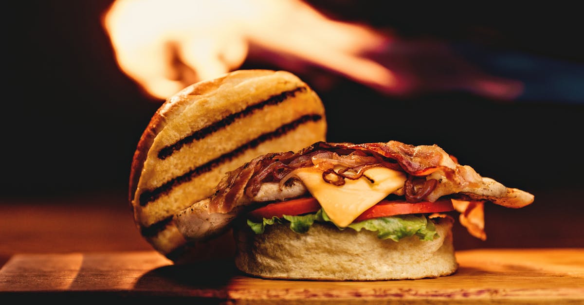 close up of a mouth watering grilled bacon and cheese burger on a wooden board with a fiery backgrou 2
